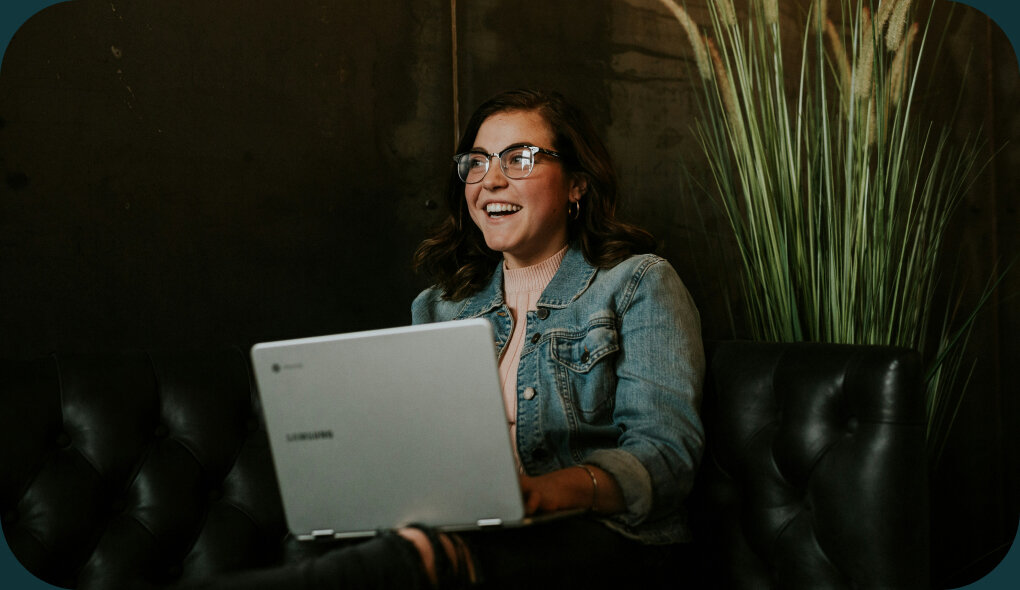 Kobieta z laptopem siedzi na kanapie.