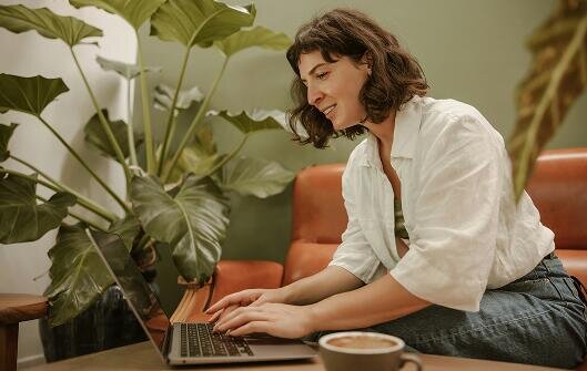 Kobieta pracująca na laptopie w kawiarni.